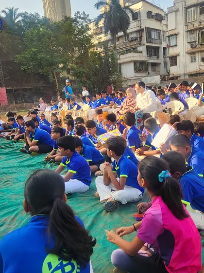 A large group of athletes listening intently at our collaborative sports camp. We bring together large communities of players for shared learning experiences.