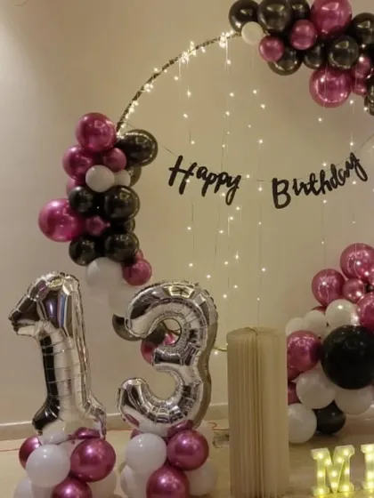A close-up of the 13th birthday home decor, showing the detail of the balloon arrangement and the light-up marquee letters.