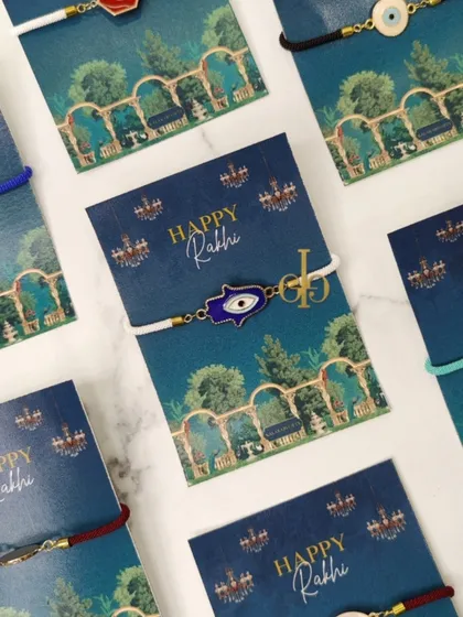 A collection of our evil eye and Hamsa hand Rakhi bracelets, presented on beautiful "Happy Rakhi" cards.