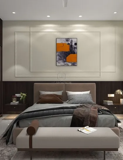A bedroom from the 'Nivasa' project, designed with a focus on simplicity and warmth. The room includes a glass-fronted wardrobe, a built-in desk, and neutral tones with dark wood accents.