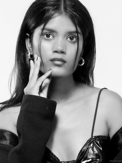 A black and white close-up portrait, with a soft and engaging expression.