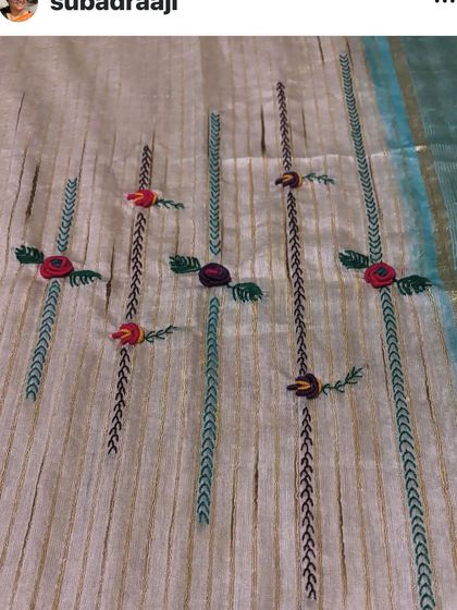 A close-up of the delicate, vine-like embroidery patterns that run vertically along this custom saree.