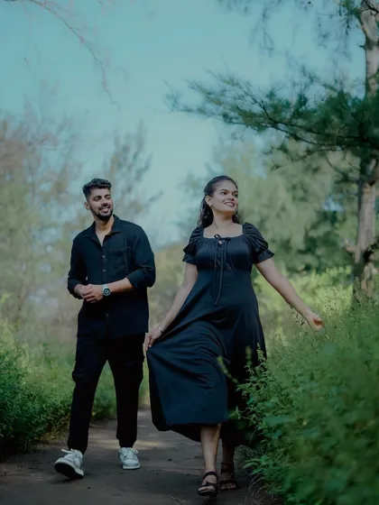 A candid shot of a couple walking through a park, capturing a natural and happy moment during their pre-wedding session.