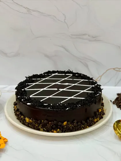My Chocolate Celebration cake is perfect for everyday celebrations. It's topped with chocolate sprinkles and a classic white chocolate lattice design, making it a simple and delicious choice for any occasion.