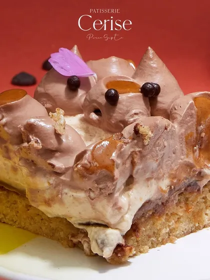 A slice of "Go Nuts for Hazelnuts" that shows off all its delicious components. It's a perfect combination of creamy, crunchy, and rich flavours.