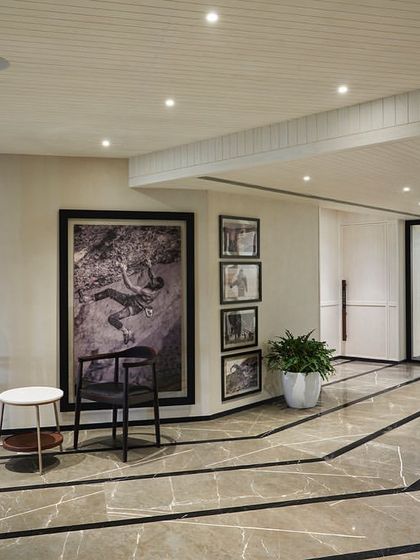 The lobby on the gym floor features a distinctive design with black marble lines that follow the angled floor plate, enhancing the geometry and flow of the space.
