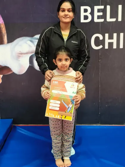 This student stands proudly with her coach after receiving her "JUMP" program certificate.