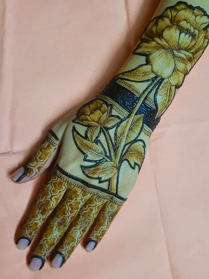 Beyond portraits, I have a passion for realistic floral henna. This design features a large, blooming peony with detailed petals and leaves, creating a bold and elegant statement piece that wraps around the arm.