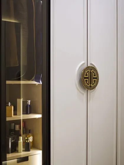 Another view of the walk-in wardrobe, showing the illuminated glass-fronted section for displaying special items.