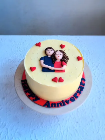 A full view of the anniversary cake with the fondant couple topper.