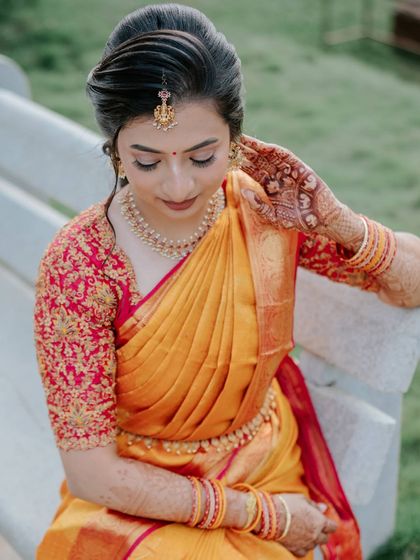 A candid moment of the bride adjusting her jewellery, her makeup looking flawless.
