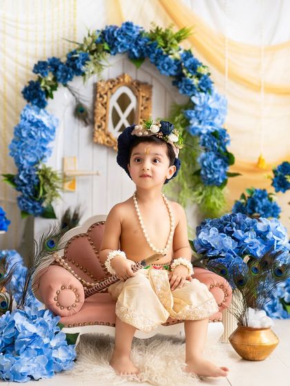 A regal pose from a little Krishna on his pink throne. The contrast of colors and textures makes this a visually stunning portrait.