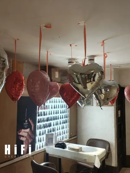 This image shows a simple cluster of hanging heart balloons. Even a small arrangement like this can effectively bring a festive, seasonal feeling to a specific corner or station within a retail store or office.