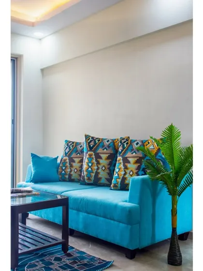A vibrant turquoise sofa brings a pop of color and personality to this simple yet elegant living space.
