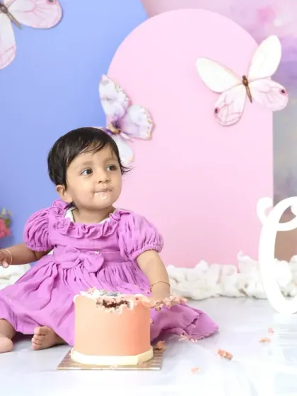 A moment of curiosity as this little girl investigates her birthday cake during a butterfly-themed cake smash session.