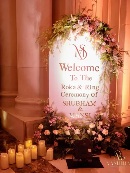 The welcome signage for this Roka and Ring Ceremony was framed with a beautiful arch of pastel roses and lush greenery, with candles at its base to greet guests with warmth and elegance.