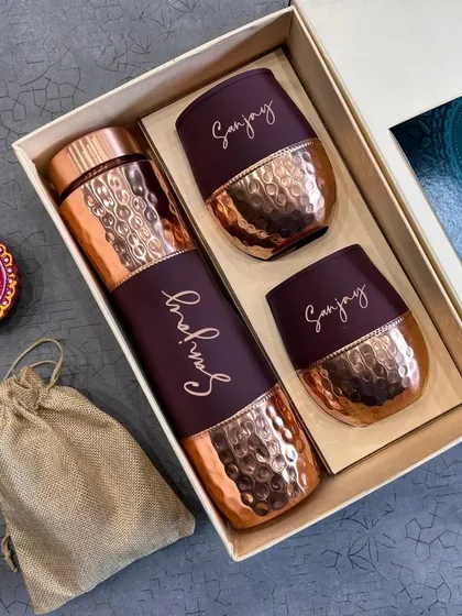 For festive occasions like Diwali, I create personalized luxury hampers. This beautiful set features a hammered copper bottle and matching tumblers, all engraved with a name, and comes with traditional diyas for a complete festive feel.