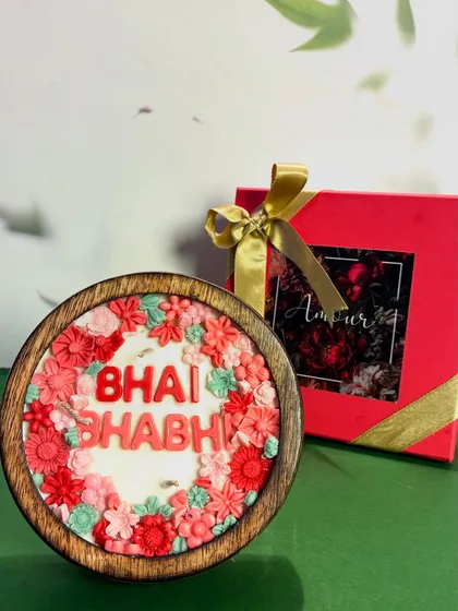 The 'Bhai Bhabhi' floral candle, pictured next to its elegant gift box. It’s a complete, ready-to-gift solution for Rakhi that is both beautiful and fragrant.