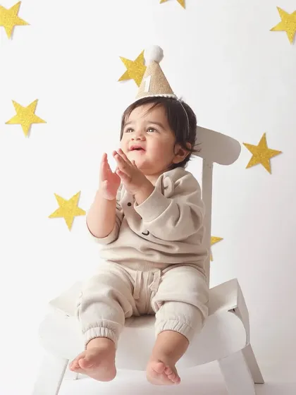 Applauding his own milestone! This little star is clapping happily during his first birthday session.