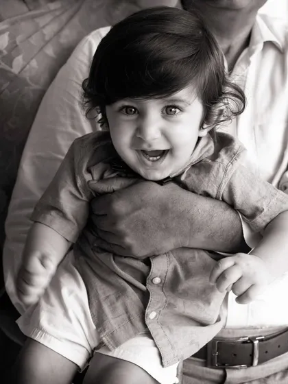 Sometimes, taking away the color lets the emotion shine through. This classic black and white portrait focuses on that bright-eyed smile and the secure feeling of being held, creating a timeless image that will never fade.