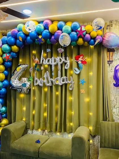 A closer view of the mermaid-themed balloon arch with under-the-sea accents and fairy lights.