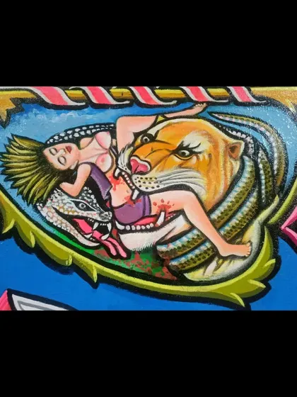 A detail from the Iron & Gold sign, showing a classic tattoo motif of a woman, a tiger, and a snake.