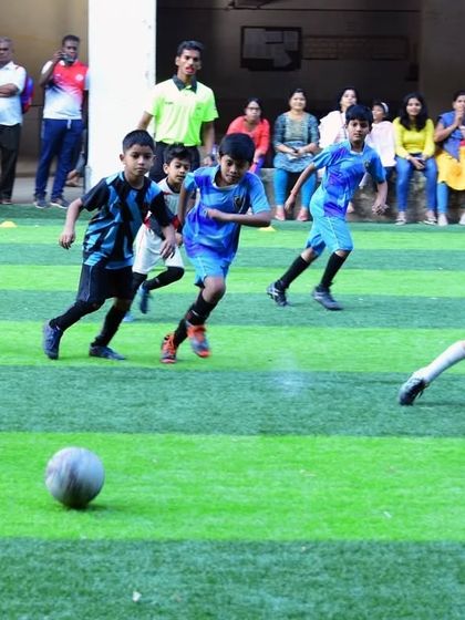 The chase is on! An action shot from an Under 8 game, with parents cheering from the sidelines.