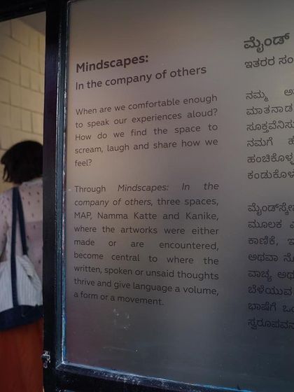 A visitor reads the bilingual curatorial text for the "Mindscapes" exhibition, which was held across three locations in Bengaluru, including our studio.
