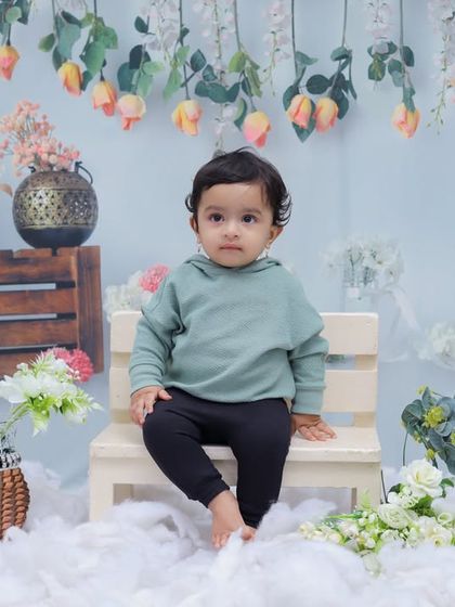 A full-body shot of a toddler sitting confidently on a bench in our cloud-themed set. The setup is perfect for capturing simple, focused portraits.