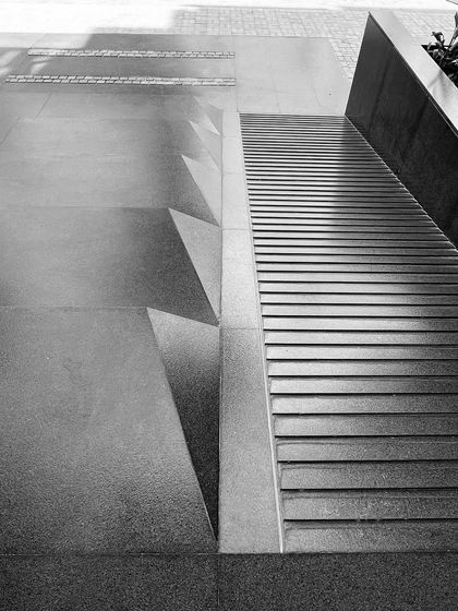 The details of the entrance at "The Treehouse" apartments, where steps and a ramp are integrated. The design considers accessibility while creating a visually interesting threshold.