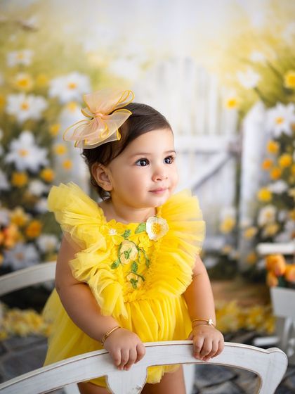 A close-up of the birthday girl, looking like a little ray of sunshine in her yellow dress.