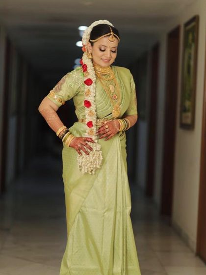 Creating a look of her own. This bride looks stunning in her pastel green Kanjeevaram, with natural makeup and a beautiful floral garland.