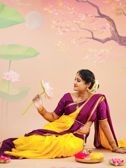 A peaceful and artistic portrait of a mother-to-be in a traditional saree, sitting gracefully and holding a lotus flower.