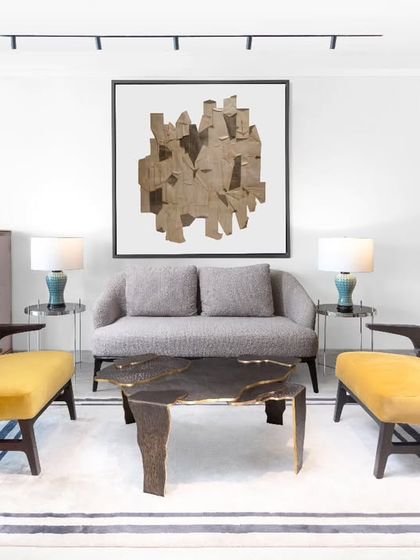 A formal seating arrangement in the Magnolia residence, anchored by the bold, artistic 'Sex and the City' coffee table from our Koko collection. The vibrant yellow armchairs provide a confident splash of colour against the neutral tones, showcasing our balanced use of statement pieces.