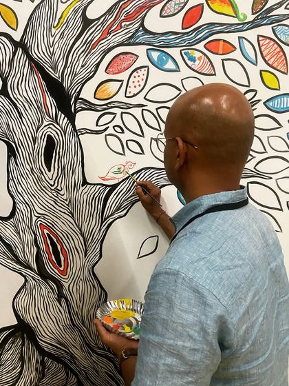 The 'Mosaic of Us' tree mural was a collaborative piece created during the Hearth Summit. I painted the outline, and attendees brought it to life by coloring in the leaves. It stands as a beautiful symbol of how individual contributions create a vibrant, collective whole.