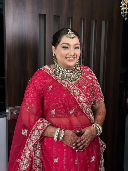 A beautiful portrait of a happy bride. Her soft glam makeup with defined eyes and a classic red outfit is a perfect inspiration for the wedding season.