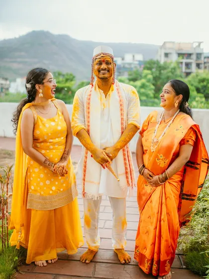 A happy, candid family portrait of the groom sharing a laugh with his family during the Haldi ceremony.