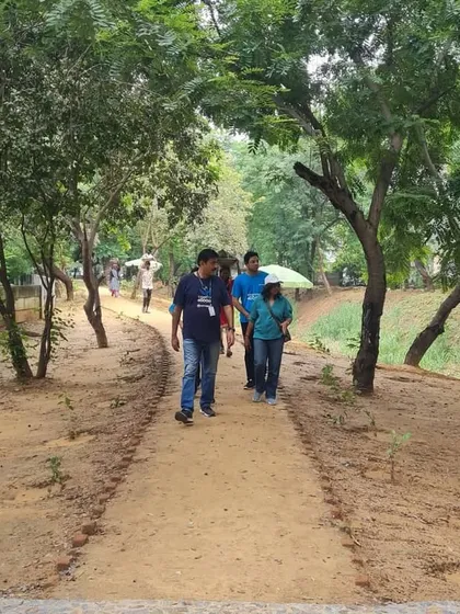 Volunteers from NTT DATA walk along a restored path at the Sector 56 creek. These green corridors provide a vital space for the community to connect with nature.