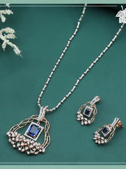 The Sapphire Dream set, a deep and spellbinding design. A central square-cut sapphire is cradled within an intricate rose gold frame, accented by a spray of marquise and round diamonds.