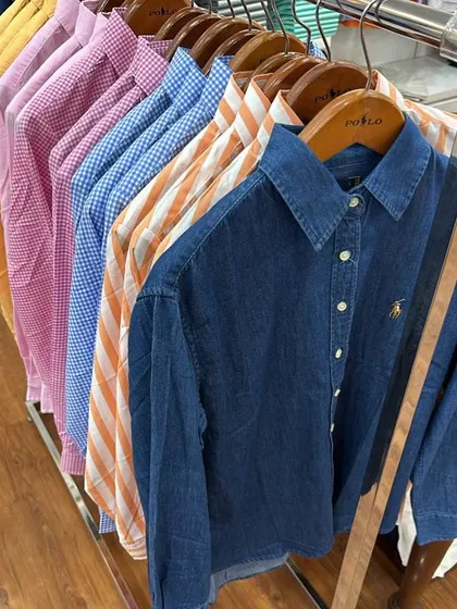 A colourful rack of authentic shirts from the Polo Ralph Lauren House in Jakarta. I can source a variety of options, including classic denim, bright checkered patterns, and bold stripes.