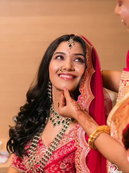 The final touches. A mother gently adjusts her daughter's chin, a simple gesture full of love, as the bride gets ready.