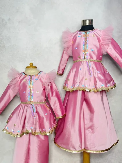 A matching peplum top and skirt set for two sisters. The design is identical, just scaled for different ages, ensuring a perfect "mini-me" look.
