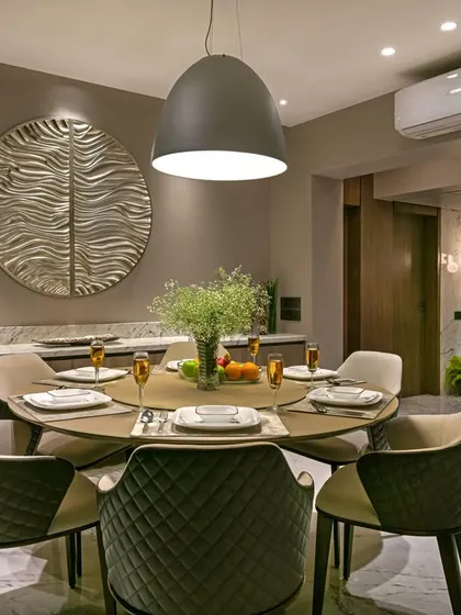 This intimate dining nook is perfect for family meals. A large pendant light anchors the round table, while quilted chairs and a textured wall art piece add layers of comfort and sophistication.