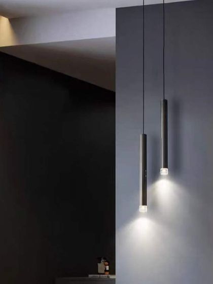 A pair of minimalist pendant lights used as bedside lighting. This is a great alternative to traditional table lamps, freeing up space on your nightstand.