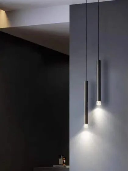A pair of minimalist pendant lights used as bedside lighting. This is a great alternative to traditional table lamps, freeing up space on your nightstand.