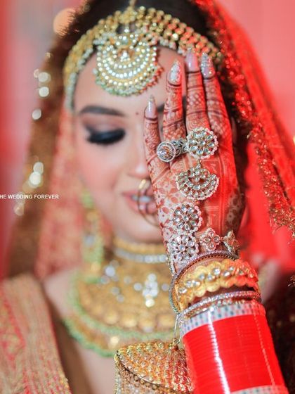 A close-up of our bridal nail work, perfectly complementing the intricate henna and stunning jewelry. Every detail matters on your big day, and we ensure your nails are flawless.