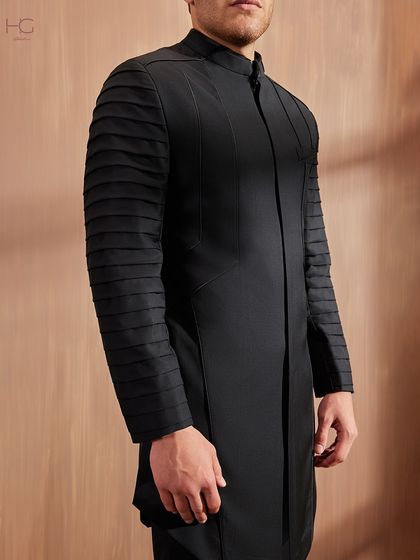 A detailed shot of the pleated sleeve, showing the precision and texture that defines this unique and modern take on ceremonial wear.