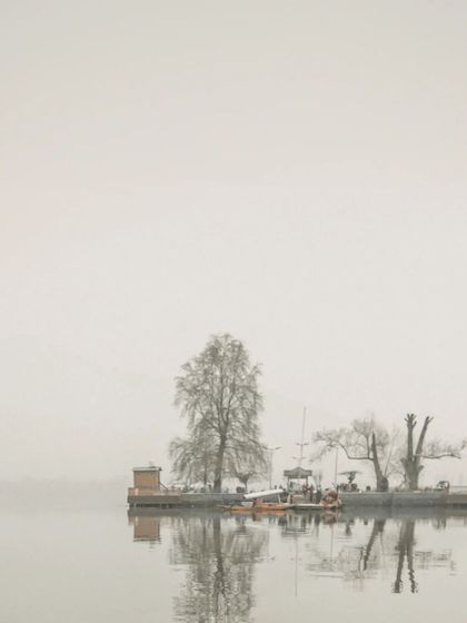 A landscape shot of a small island on Dal Lake, shrouded in mist. We use these scene-setting shots to build the narrative of your destination pre-wedding film and album.