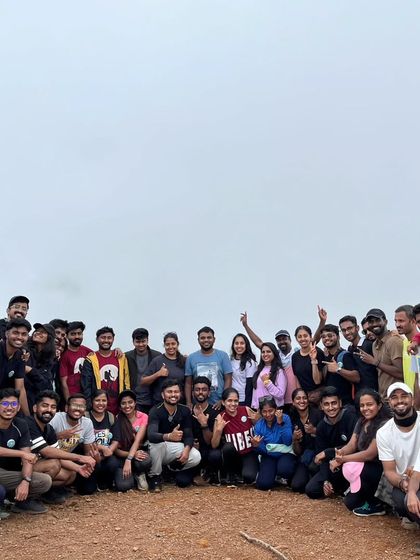 A large group of happy trekkers celebrating at the summit. The more, the merrier on our weekend trips.
