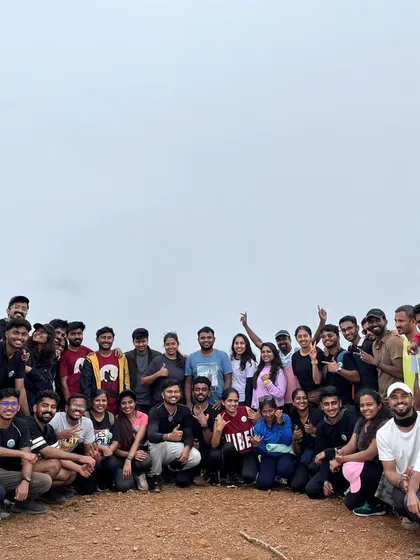 A large group of happy trekkers celebrating at the summit. The more, the merrier on our weekend trips.